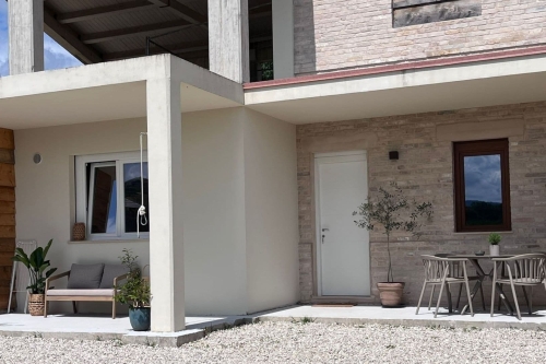Appartement Luce in Italië bij Agriturismo Camping Vista Fermo in Le Marche Overzicht van Vista Fermo met het gebouw waarin Appartement Luce is gevestigd, gelegeven in het groene Italiaanse heuvellandschap
