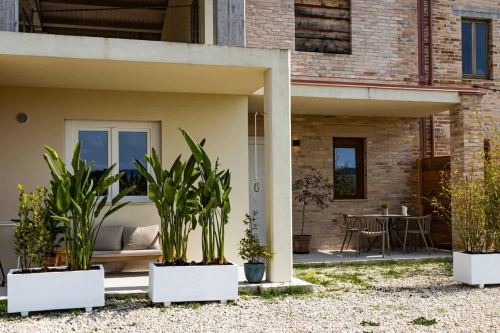 Appartement Luce in Italië bij Agriturismo Camping Vista Fermo in Le Marche Overzicht van Vista Fermo met het gebouw waarin Appartement Luce is gevestigd, gelegeven in het groene Italiaanse heuvellandschap
