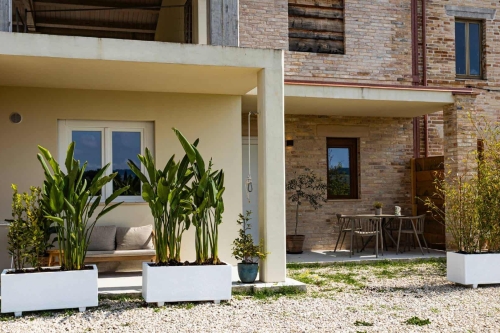 Appartement Luce in Italië bij Agriturismo Camping Vista Fermo in Le Marche Overzicht van Vista Fermo met het gebouw waarin Appartement Luce is gevestigd, gelegeven in het groene Italiaanse heuvellandschap