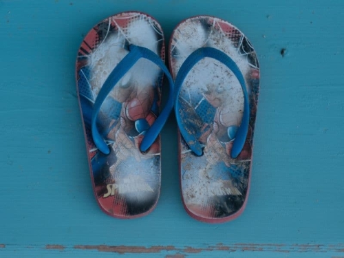 Paar kleine kinderslippers op een blauwe ondergrond tijdens een vakantie bij Vista Femro