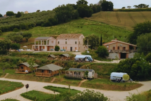 Overzicht van Vista Fermo met het gebouw waarin Appartement Luce is gevestigd, gelegeven in het groene Italiaanse heuvellandschap