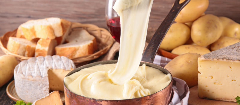Aligot met gesmolten kaas, aardappels en brood op tafel