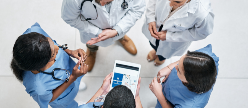 Groep medische professionals in overleg met tablet in het midden