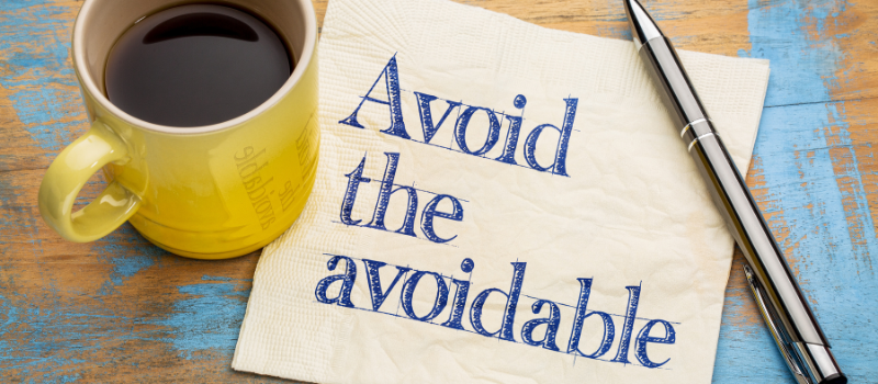 Servet met tekst 'Avoid the avoidable' naast koffie en pen