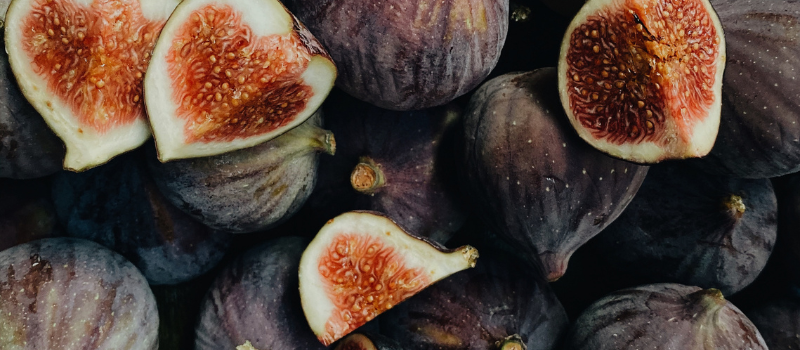 Stapel rijpe paarse vijgen met enkele gehalveerde, sappig gezond fruit