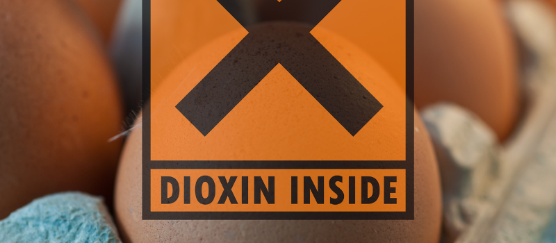 Close-up van ei met waarschuwingslabel 'Dioxin Inside' in oranje
