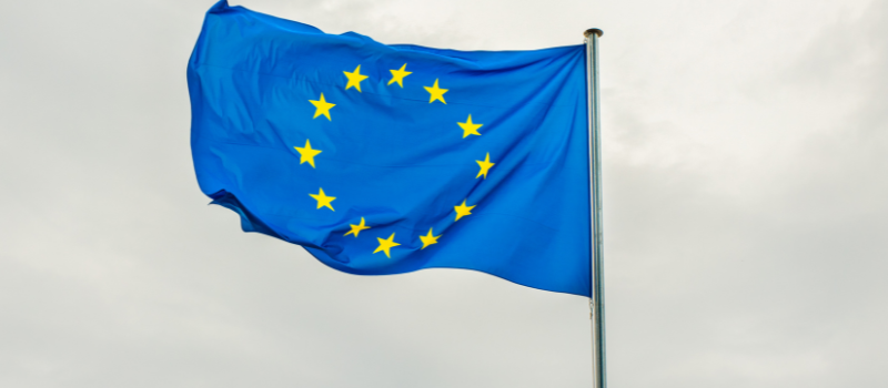 Europese Unie vlag wappert in de wind met sterren op blauwe achtergrond