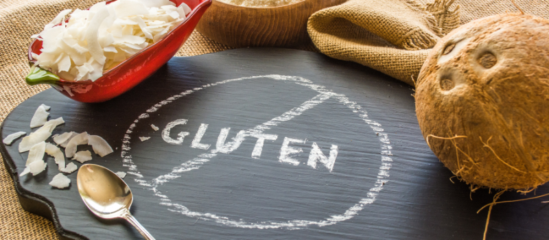 Leistenen bord met doorgehaald glutensymbool en kokosnoot.