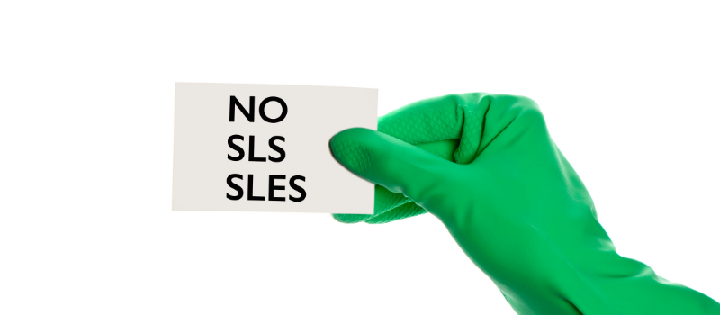Groene handschoen houdt kaart met tekst 'NO SLS SLES'