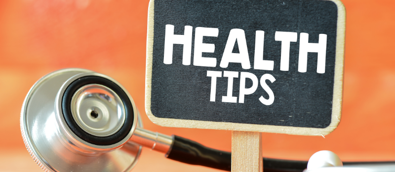 Bordje met tekst 'Health Tips' naast stethoscoop en oranje achtergrond