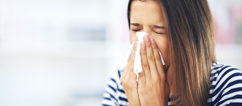 Vrouw snuit neus, symptomen van hooikoorts of allergie