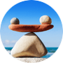 Perfect gebalanceerde stenen op het strand onder blauwe lucht