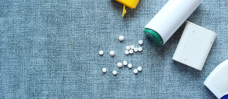 Verspreide witte zoetstoftabletten naast diverse plastic verpakkingen