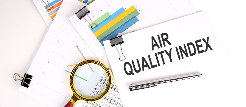 Vergrootglas naast grafieken en document met titel Air Quality Index