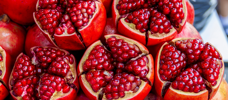 Stapel open granaatappels toont felrode zaden, rijk aan antioxidanten