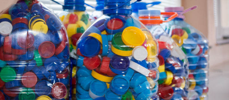 Gevulde flessen met kleurrijke plastic doppen voor recycling