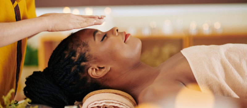 Vrouw ontvangt ontspannende reiki-sessie in spa