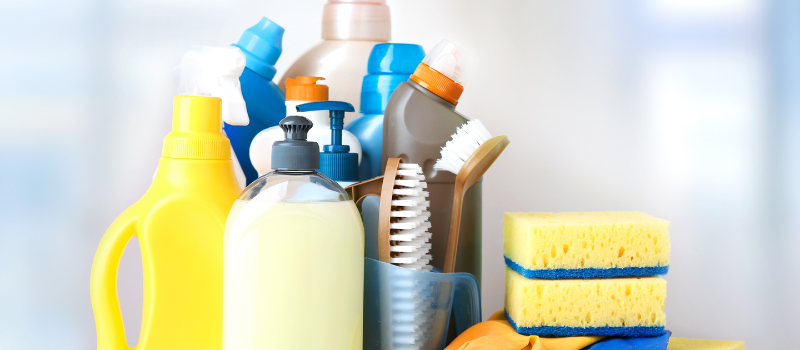 Diverse schoonmaakmiddelen, sponzen en borstels op tafel, schoonmaakproducten