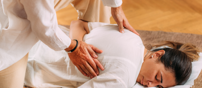 Therapeut geeft drukpuntmassage op rug van vrouw