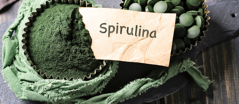 Spirulina poeder en tabletten in bakjes met label 