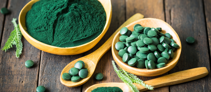 Spirulina poeder en tabletten in bakjes met label 