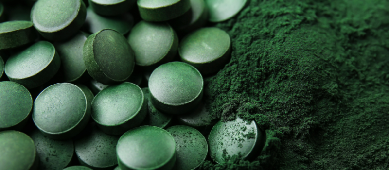 Close-up van spirulina-tabletten en poeder, een populair superfood voor gezondheid.