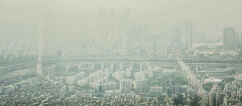 Luchtfoto van een stedelijk gebied bedekt door smog en luchtvervuiling
