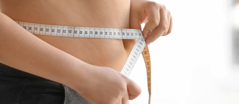 Persoon meet taille met centimeter, resultaat van vetverbranding
