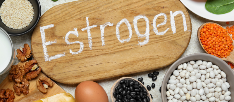 Houten bord met ‘Estrogen’ en oestrogeenrijke voeding zoals noten en bonen