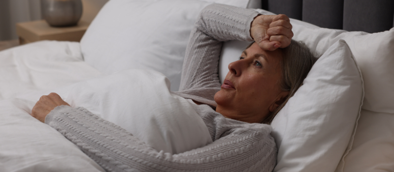 Vrouw ligt wakker in bed, mogelijk door hormonale verandering bij vetverbranding