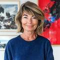 Portretfoto van Nadia Vermeer met een vriendelijke glimlach, tegen een kleurrijke achtergrond.