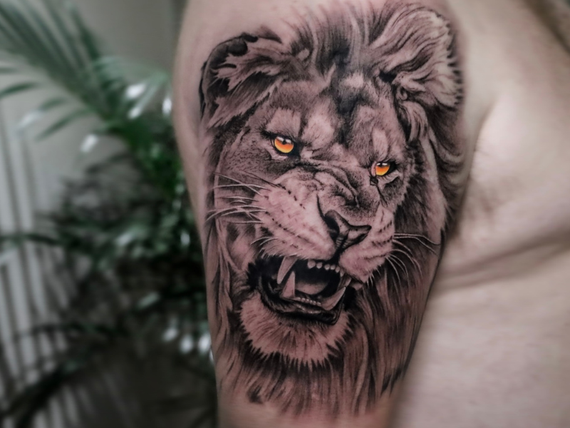 Realisme tattoo Genk leeuw met oranje ogen