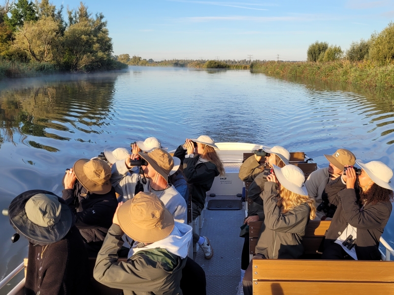 Kleine groep op vogelexcursie met Vogelwachter Adriaan in het ochtendlicht.