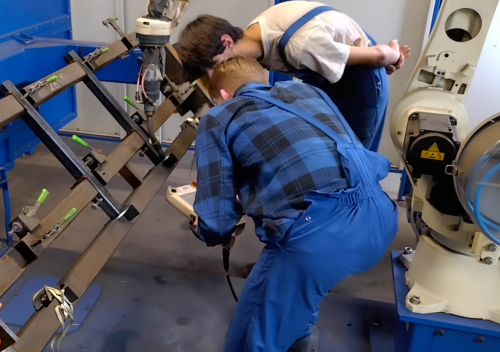 Job van Oirschot bedient teach pendant en leert robot programmeren