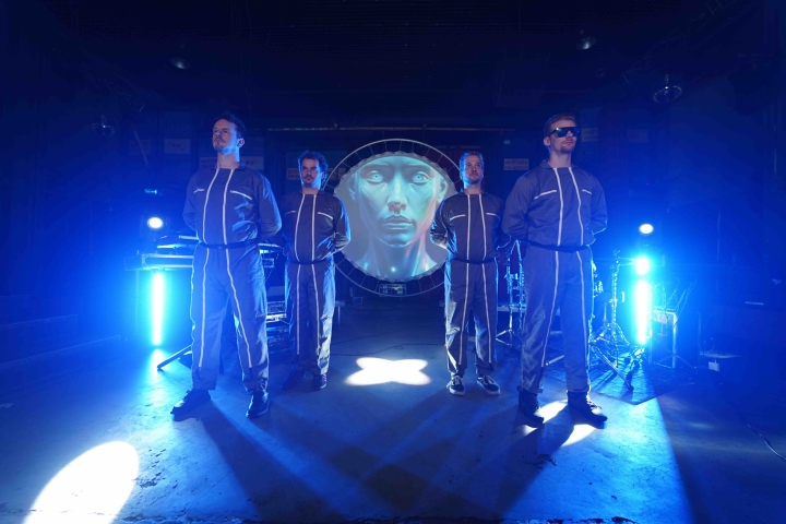 VoxTechnik live 80s synthpop Band press photo - Blue VoxTechnik performing live 80s synthpop on stage with futuristic visuals and robot as circular screen, all in blue lights