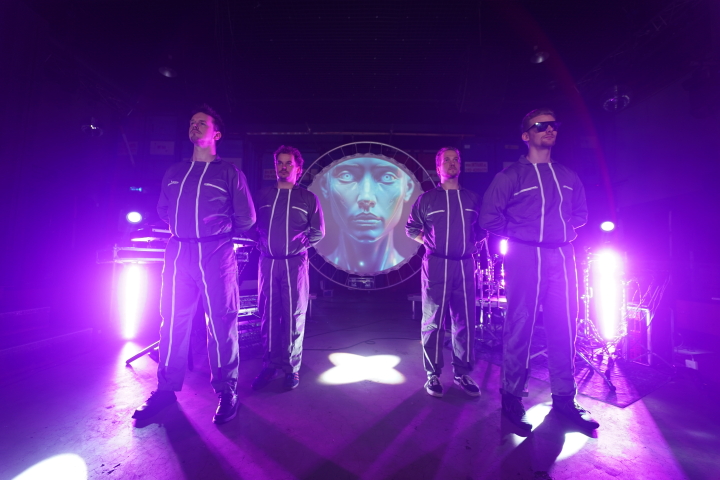VoxTechnik performing live 80s synthpop on stage with futuristic visuals and robot as circular screen