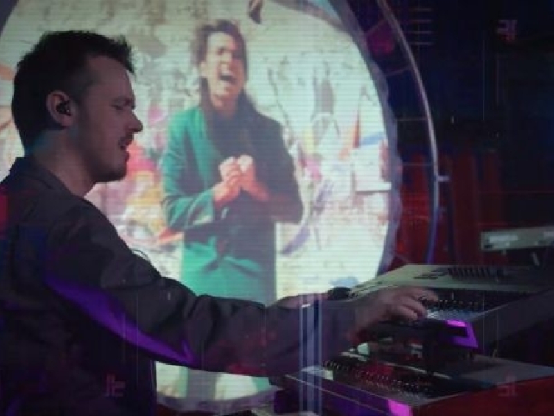 VoxTechnik LIVE synths on stage VoxTechnik LIVE synth player on stage with circular screen with videoclip in background