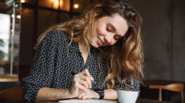 jonge vrouw schrijft bij kopje koffie