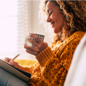 Vrouw zit in de zetel en schrijft