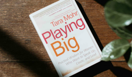 Het boek playing big n Tara Mohr ligt op een houten tafel