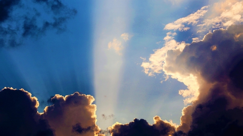 patronen doorbreken: zon schijnt van achter grijze donkere wolken