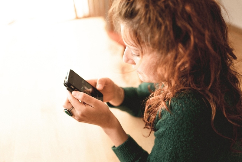 een jonge vrouw kijkt op haar smartphone