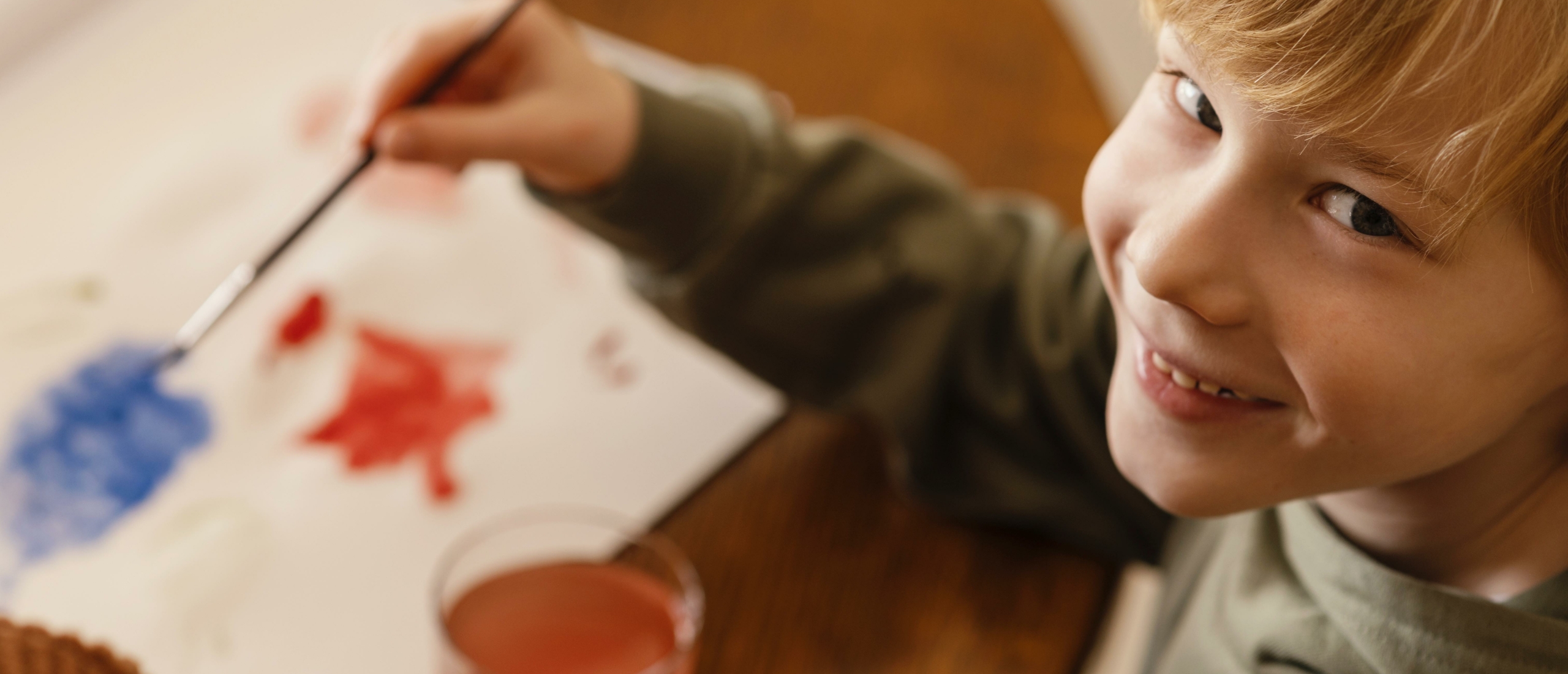 close-up-smiley-child-painting-paper