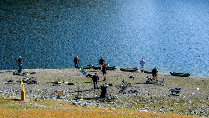 Bikeraft stop aan de Rursee tijdens YALPAK teambuilding in de Eifel Team tijdens een pauze aan de Rursee tijdens een bikeraft teambuilding van YALPAK in de Eifel, met packrafts en mountainbikes op de oever.