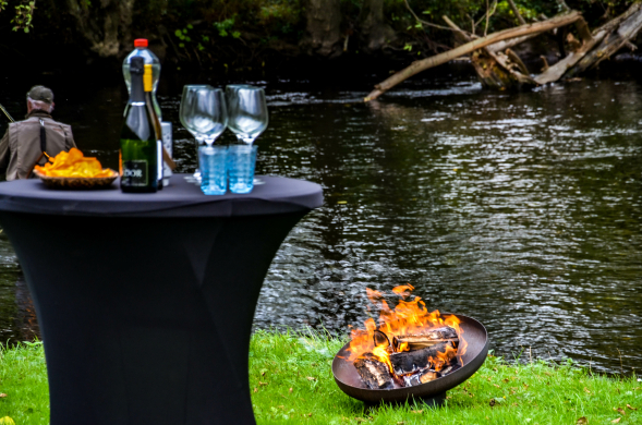 Aperomoment bij een kampvuur aan het water na een bikeraft expeditie tijdens een YALPAK teambuilding in de Eifel.