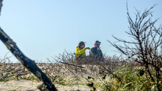 Twee deelnemers in gesprek in de duinen tijdens een tweedaagse YALPAK team experience aan de Côte d’Opale
