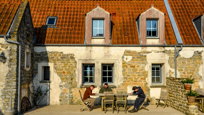 Kernteam dat samen aan tafel zit tijdens een reflectiemoment op een authentieke locatie tijdens een YALPAK team experience