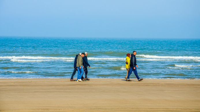 Team dat samen langs het strand wandelt tijdens een tweedaagse YALPAK team experience aan de Côte d’Opale