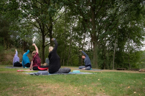 Yoga in de natuur met lateroflexie wervelkolom in zit