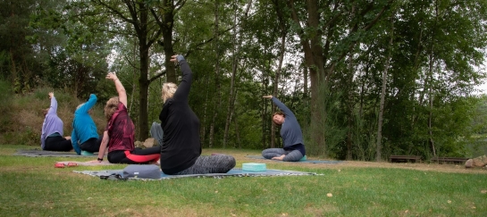 Yoga in de natuur met lateroflexie wervelkolom in zit